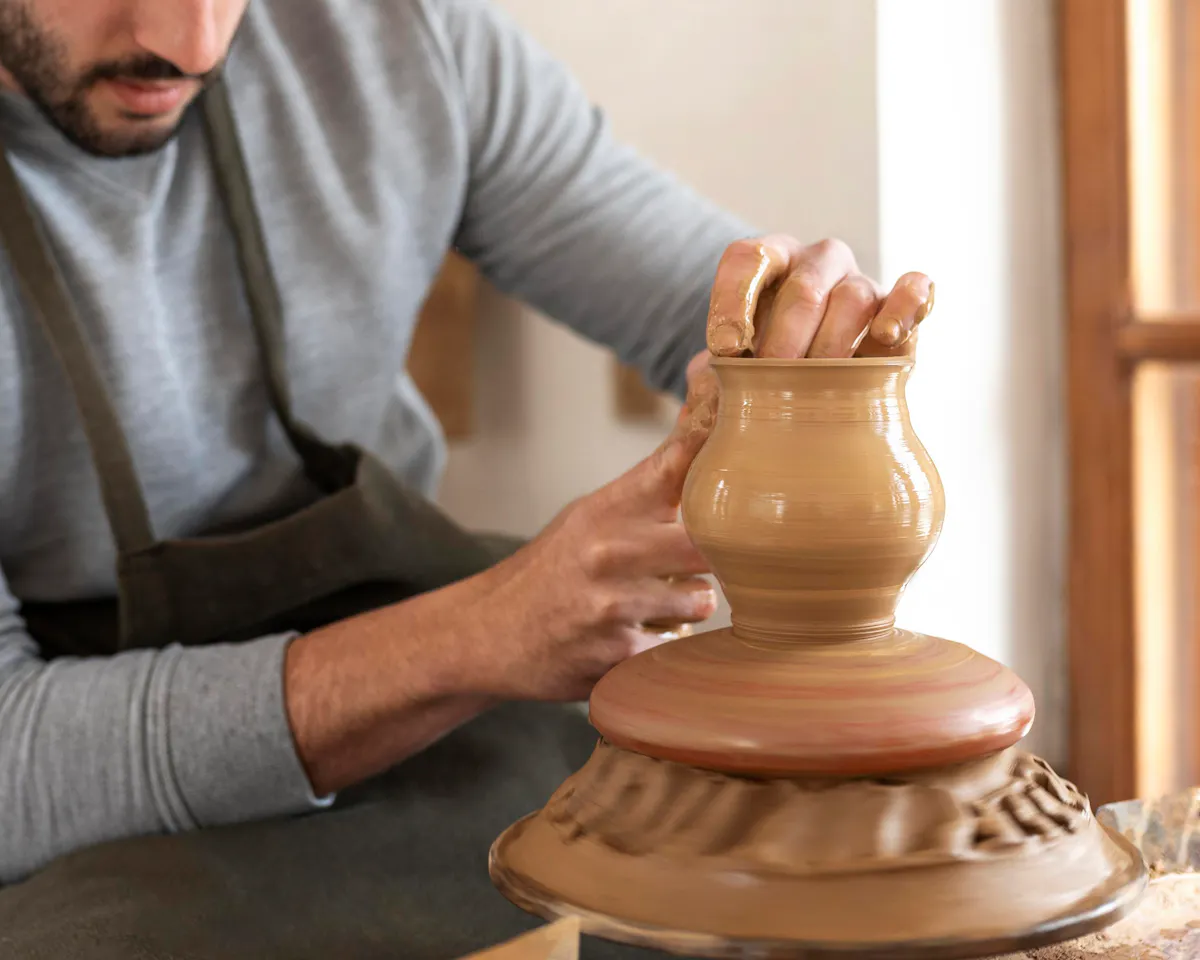 A potter shaping a vessel on the wheel